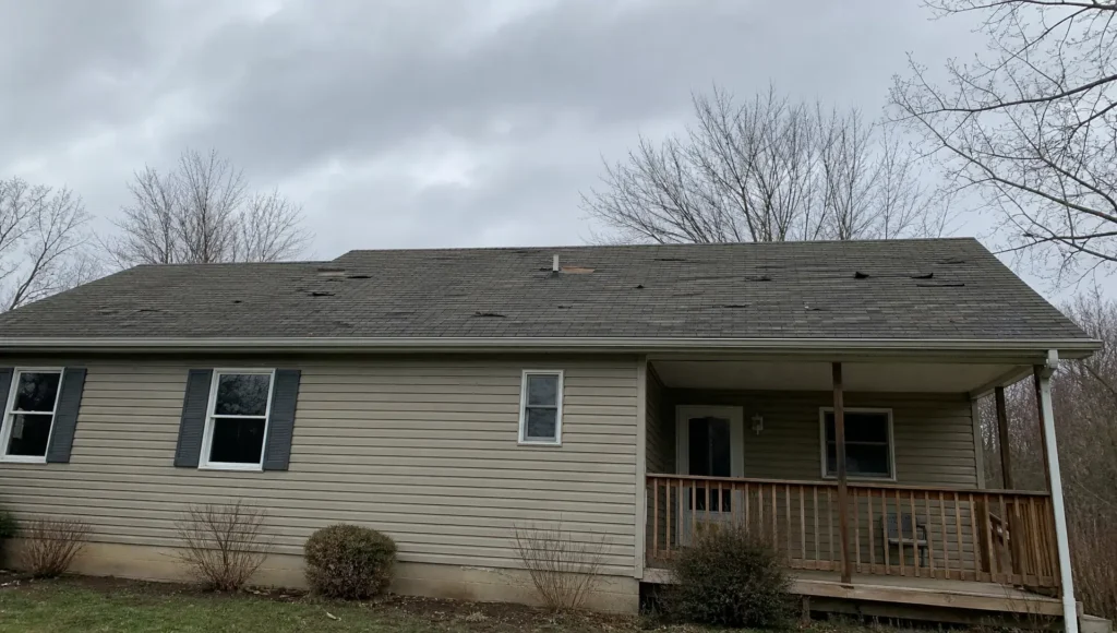 Indiana home with missing and damaged roof shingles showing signs of needing replacement